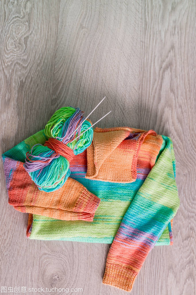 針織。針織毛衫。多色球的紗線用針附近上木制的灰色背景的手工產品。頂視圖。復制空間